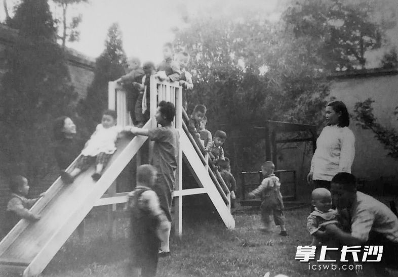 滑梯在长沙俗称“梭梭板”。这是上世纪50年代长沙一家托儿所内幼儿们在老师的看护下玩“梭梭板”。当时,长沙托儿所内儿童游戏设施并不多,但每一样都会让孩童们异常开心。